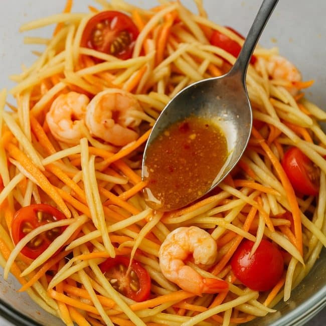Zubereitung des Thai-Papaya-Salats mit Garnelen, Gemüse und Limetten-Dressing