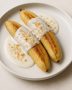 Bananen, Kokosmilch, Vanille und Erdnüsse auf Holzbrett
