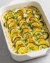 Überbackenes Kartoffel-Gemüse-Gratin mit Hüttenkäse aus Kartoffeln, Zucchini und Hüttenkäse in Auflaufform serviert